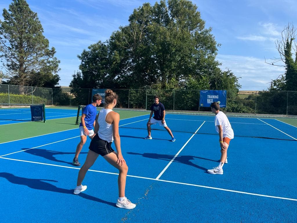 A doubles footwork session on blue courts